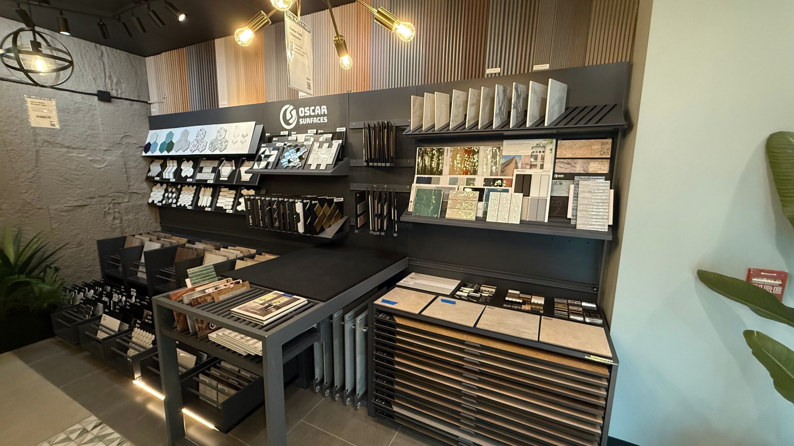 An interior showroom display featuring a wide selection of tile, stone, and surface samples from Oscar Surfaces for home builders to choose from.
