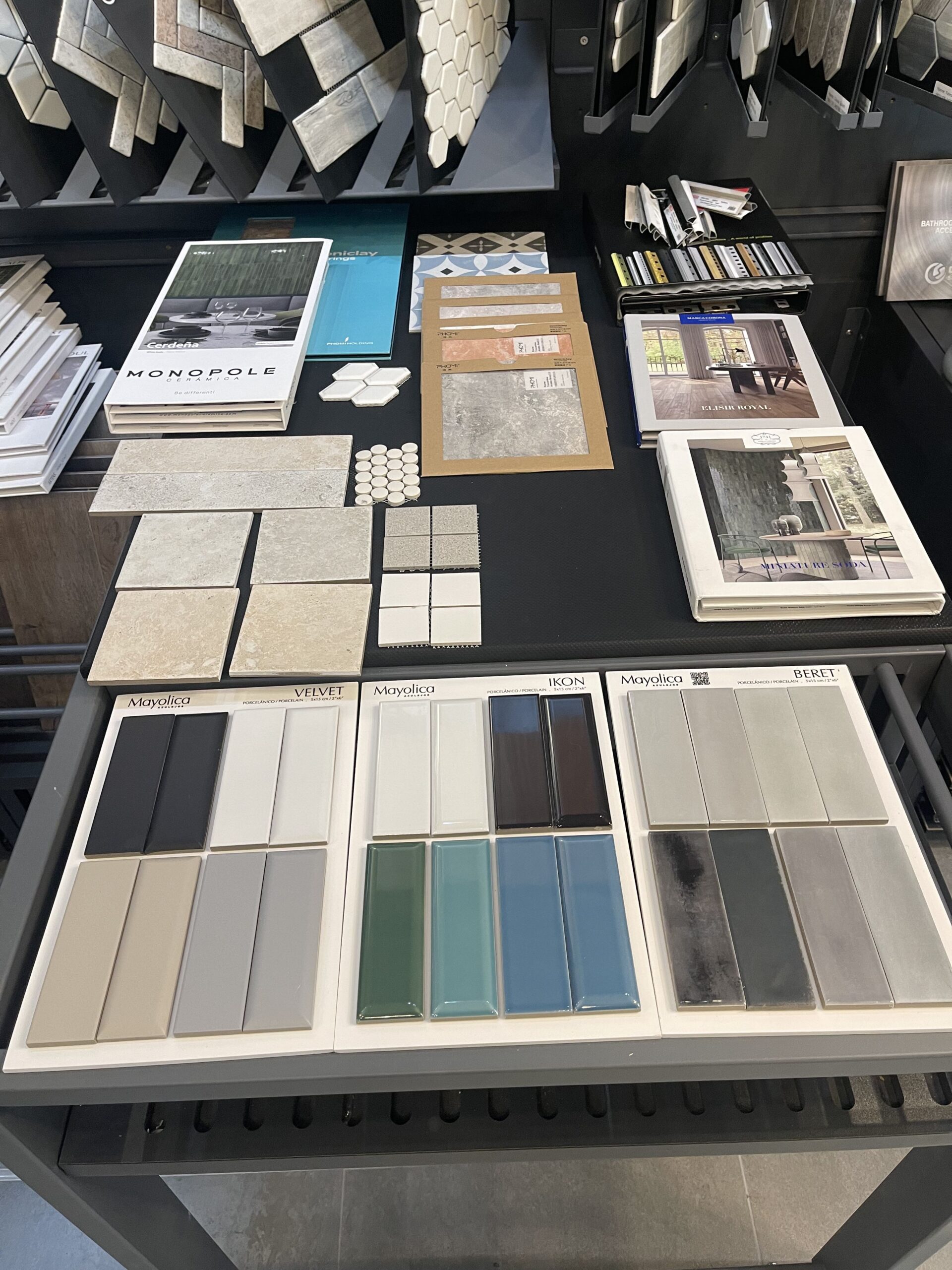 A close-up shot of various tile and surface samples, including subway tiles and mosaics, highlighting the range of interior materials available from Oscar Surfaces.