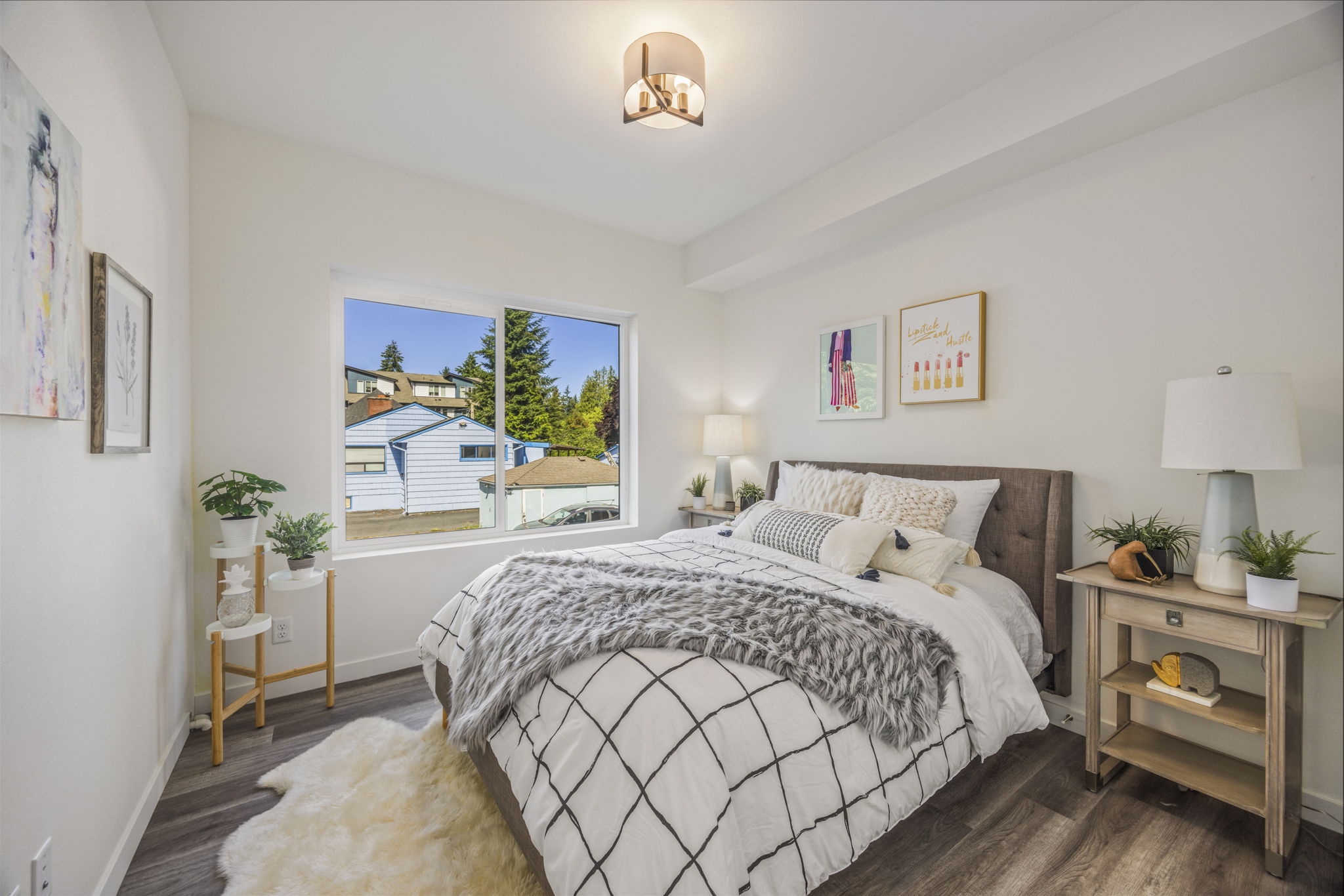 A modern bedroom with a large window, warm lighting, and a cozy bed, representing a comfortable living space in the new apartments.