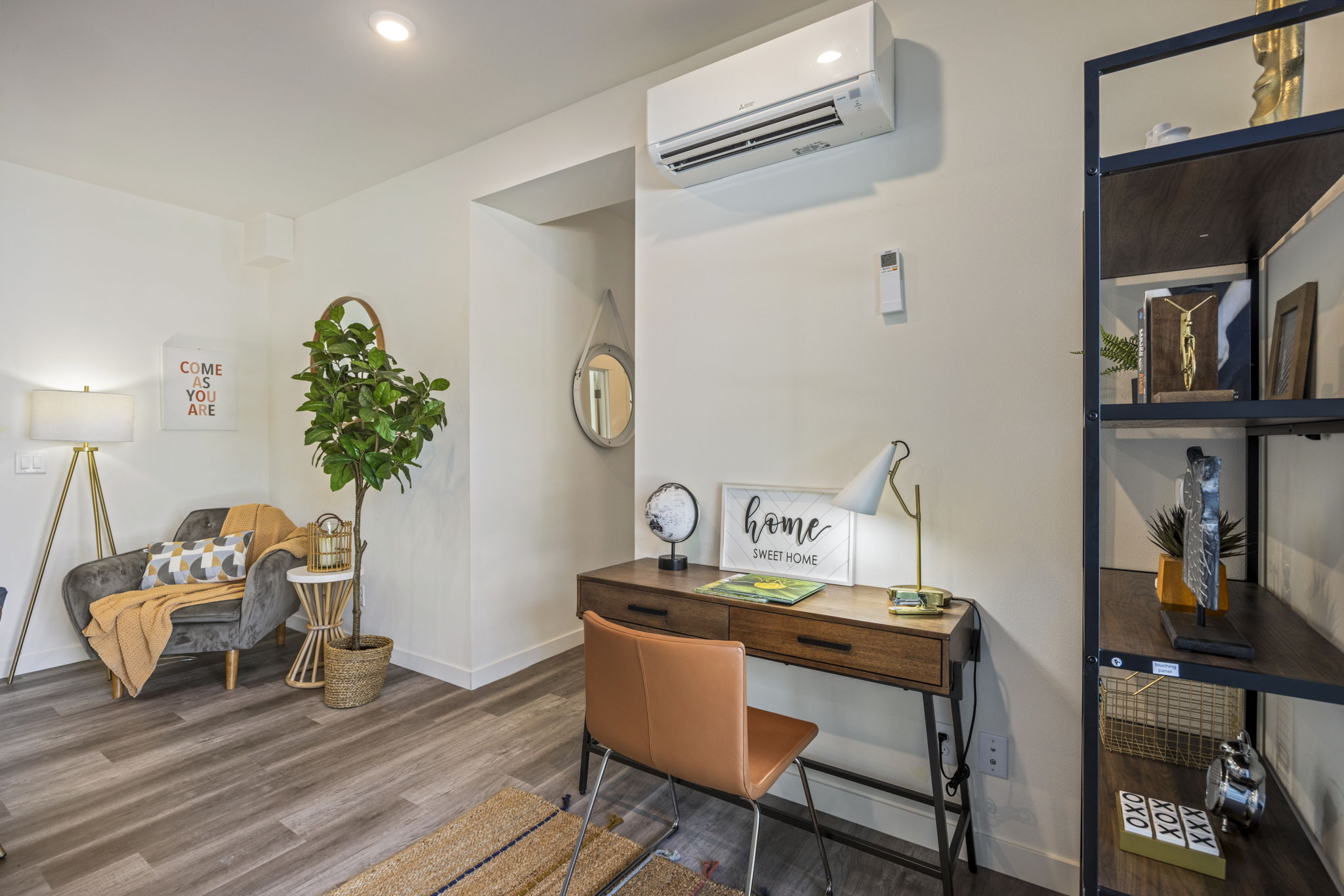 A home office area in a modern apartment, featuring a stylish desk and shelves, showcasing the functional and versatile design of the units.