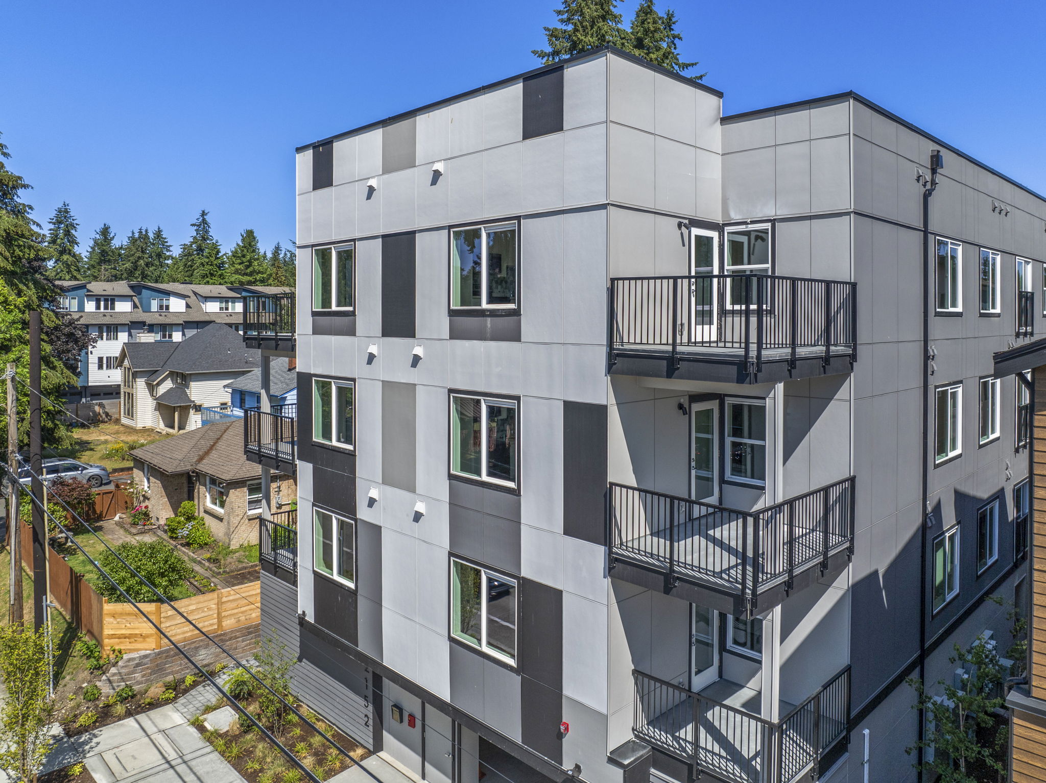 An exterior view of a modern apartment building with a multi-toned facade and balconies, showcasing the contemporary architecture of the Shoreline project.