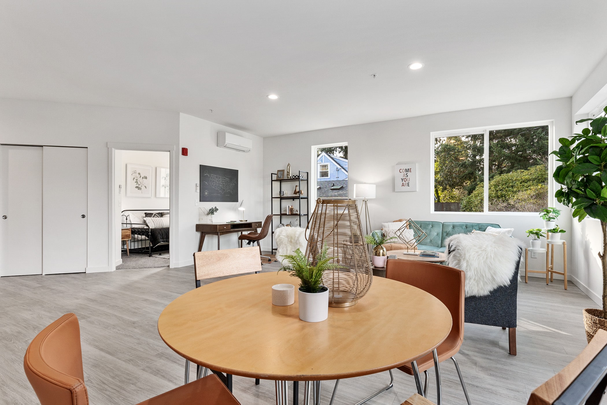 A spacious open-concept living and dining area in a Shoreline apartment, featuring modern furniture and luxury vinyl plank flooring installed by Oscar Surfaces.