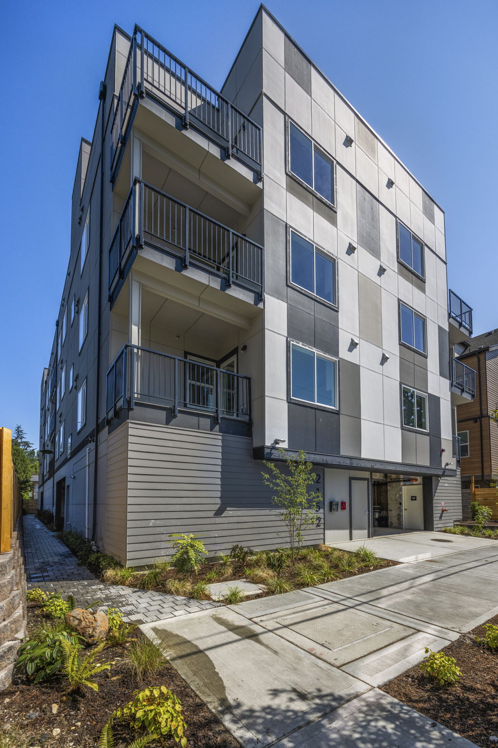 The exterior of a newly completed 22-unit apartment building in Shoreline, showcasing the modern, multi-story architecture by TP Home.