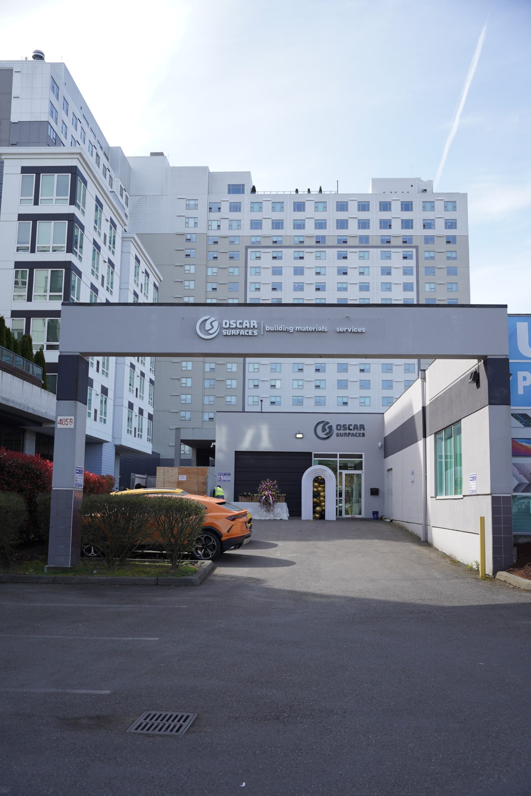 The exterior of the newly completed Oscar Surfaces showroom, showing the modern building with an arched entrance and the company's signage, built by TP Home.