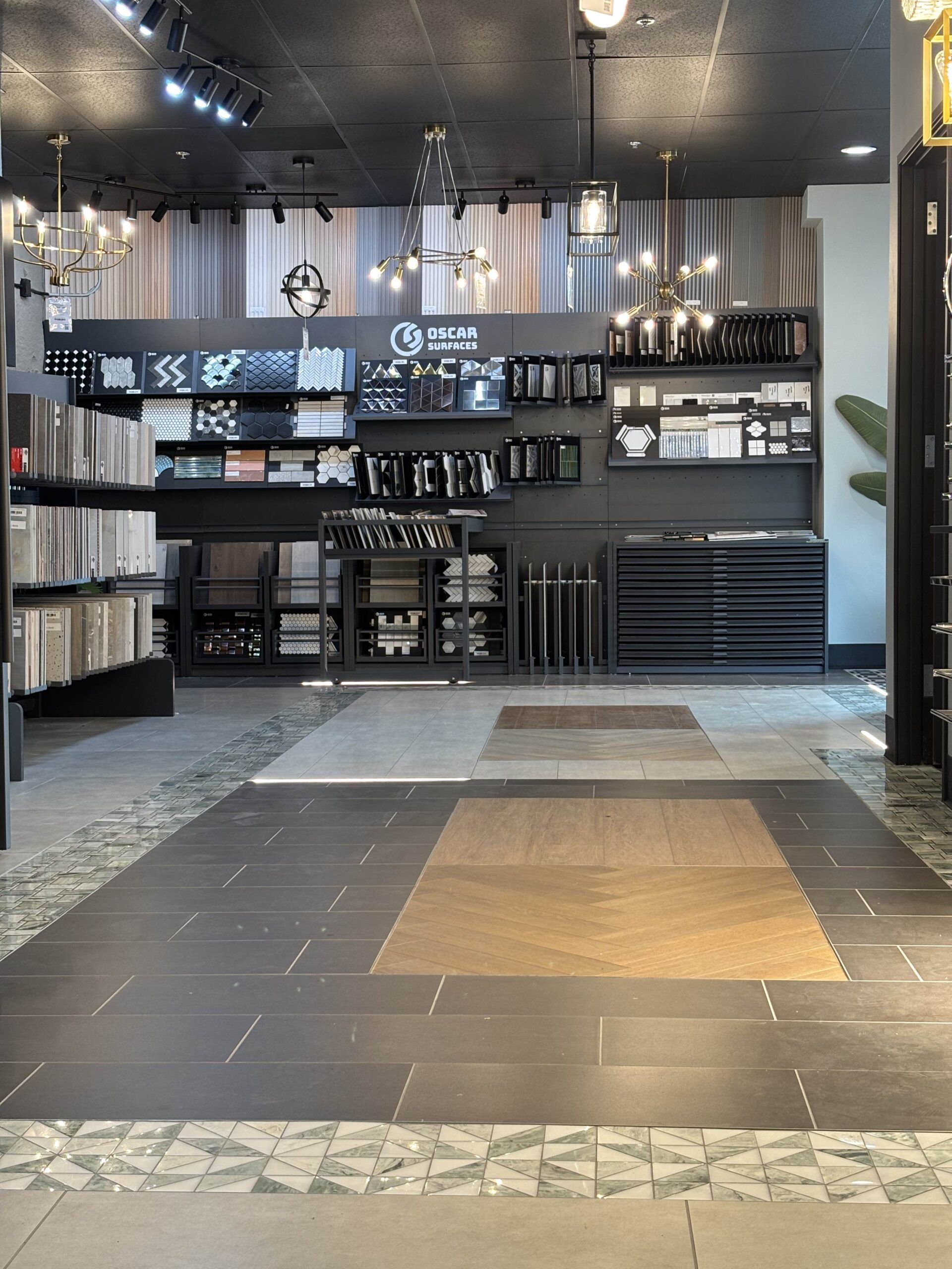 A wide view of the Oscar Surfaces showroom, highlighting various floor tile patterns and material displays used in the Tukwilla build.
