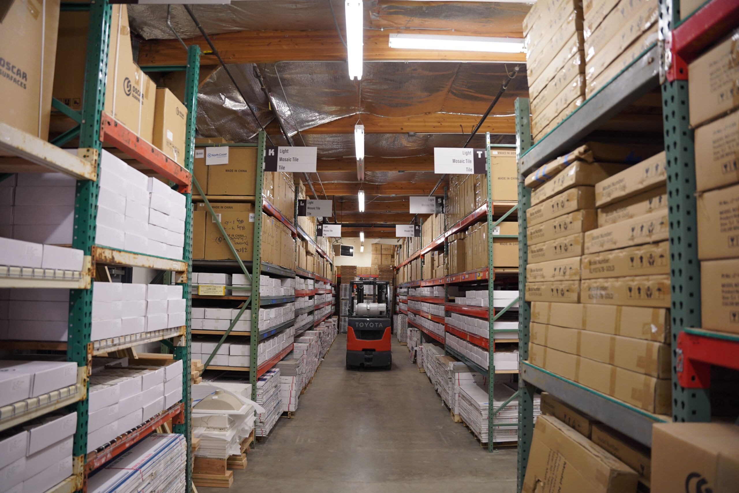 A forklift in the warehouse aisle of Oscar Surfaces, illustrating the logistical operations behind providing finishes for TP Home builds.