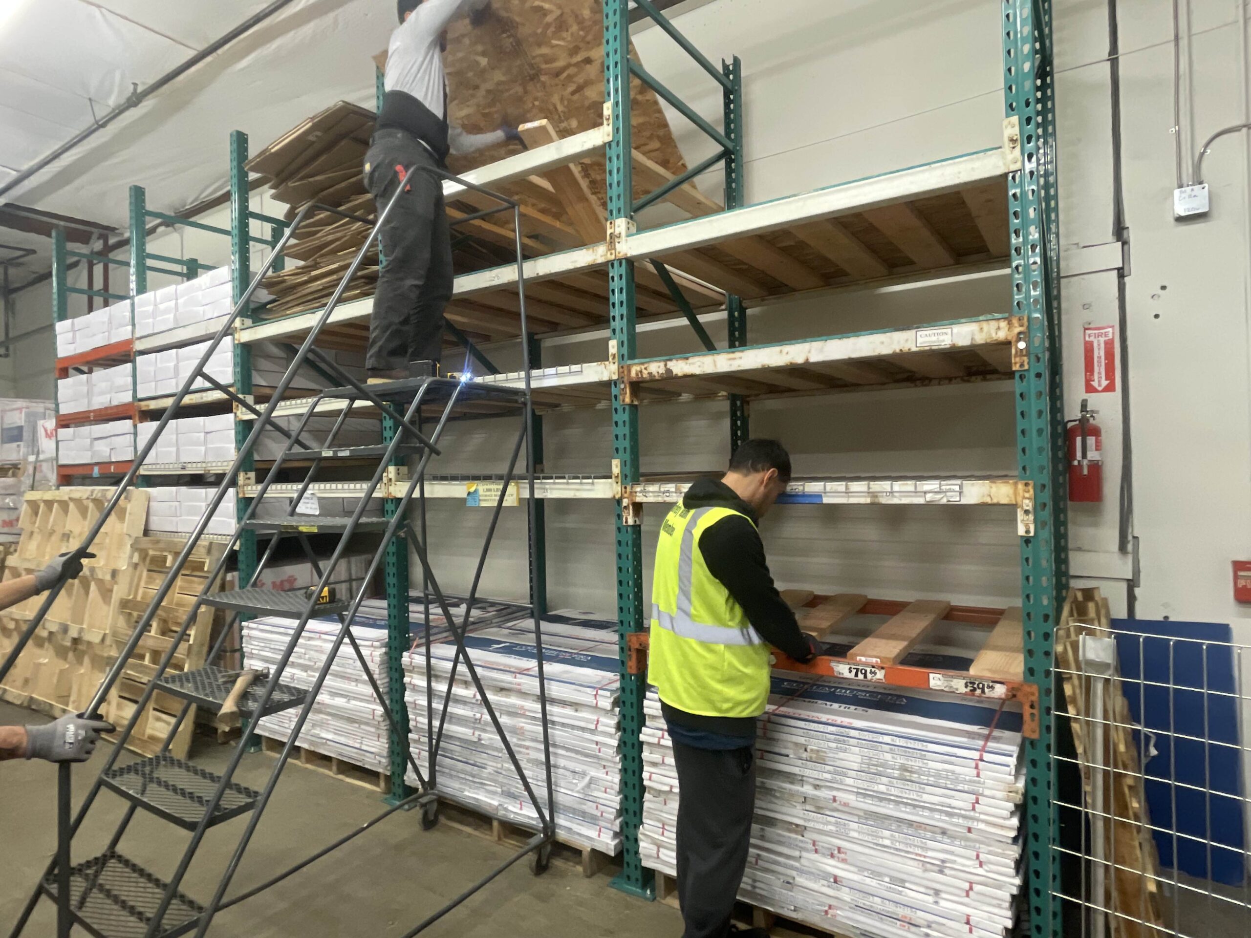 Warehouse workers organizing large pallets of building materials, representing the organized inventory that supplies the Tukwilla showroom and TP Home projects.