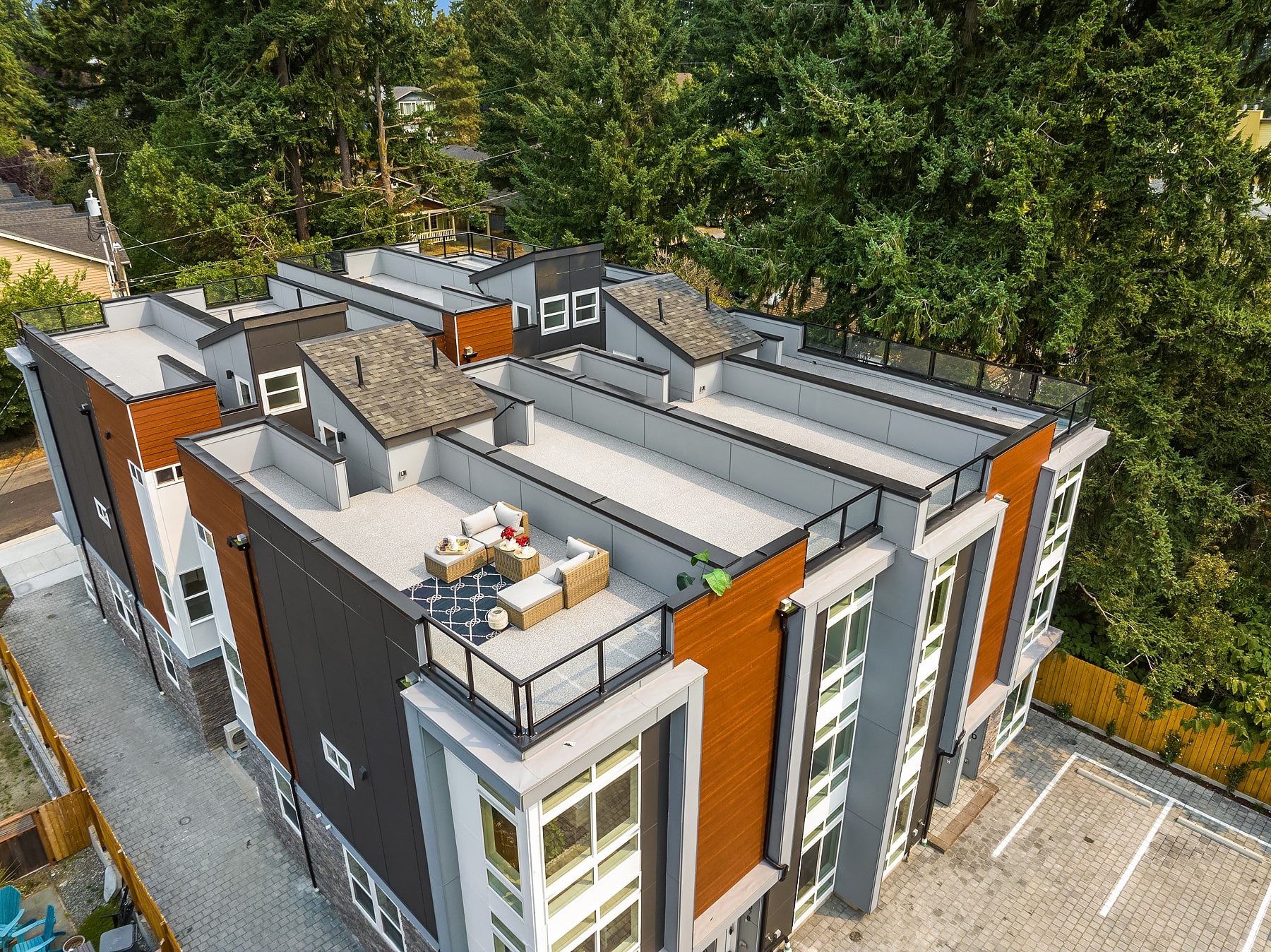 An aerial view of a modern townhome with a private rooftop patio, showing the outdoor living space of an exclusive ADHG development.
