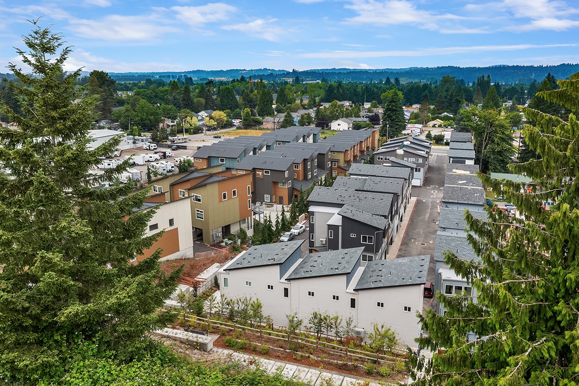 An aerial view of a residential development featuring multiple modern townhomes, demonstrating the scope of work completed by TP Home and its partners.