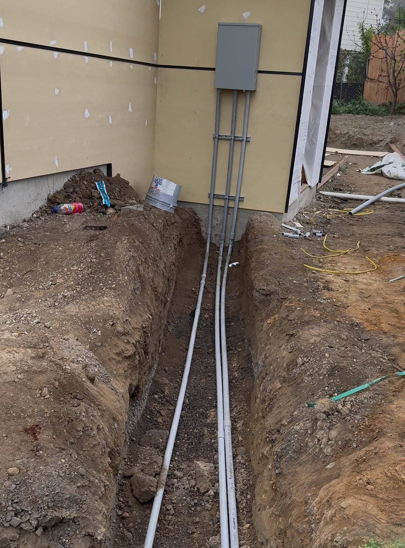 An excavated trench with pipes for underground utilities, highlighting the crucial excavation and infrastructure work for new home construction.